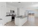 Bright kitchen features white cabinets, stainless steel appliances, and a granite island with sink at 1408 W Hess Ave, Coolidge, AZ 85128