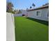 Expansive backyard featuring artificial turf, privacy fence, and an outdoor fire pit seating area at 2025 N 87Th Way, Scottsdale, AZ 85257