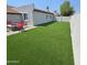 Well-maintained backyard with artificial grass, fire pit, and a freshly painted privacy fence at 2025 N 87Th Way, Scottsdale, AZ 85257