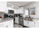 Modern kitchen features white cabinetry, stainless steel appliances, and a sink under a bright window at 2025 N 87Th Way, Scottsdale, AZ 85257