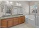 Bathroom with double sinks, granite countertops, bathtub, and separate shower with glass door at 21192 E Stirrup St, Queen Creek, AZ 85142