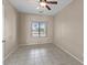 Neutral bedroom with a ceiling fan, tile floor, and window overlooking the backyard at 21192 E Stirrup St, Queen Creek, AZ 85142