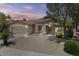 Single-story home with a two-car garage, desert landscaping, small front porch and mature trees at 21192 E Stirrup St, Queen Creek, AZ 85142