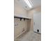 Functional laundry room with tiled floor, overhead shelf, and hook-ups for a washer and dryer at 21192 E Stirrup St, Queen Creek, AZ 85142