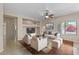 Open living room featuring tile and wood flooring, a ceiling fan, built-in shelving, and large windows at 21192 E Stirrup St, Queen Creek, AZ 85142