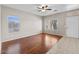 Bright, open living room featuring hardwood floors, tile, a ceiling fan, and large windows at 21192 E Stirrup St, Queen Creek, AZ 85142