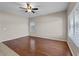 Well-lit living room with hardwood floors, a ceiling fan, and multiple windows for natural light at 21192 E Stirrup St, Queen Creek, AZ 85142