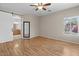 Main bedroom features wood flooring, ceiling fan, barn door to bathroom, and a window for natural light at 21192 E Stirrup St, Queen Creek, AZ 85142