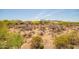 A backyard featuring desert landscape, sparse vegetation, and surrounding homes under a bright, sunny sky at 2425 W Bronco Butte Trl # 2028, Phoenix, AZ 85085