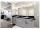 Bathroom featuring double sink vanity with black countertop and large mirror, along with carpeted floor at 2425 W Bronco Butte Trl # 2028, Phoenix, AZ 85085