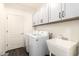Clean laundry room equipped with a washing machine, dryer, sink, and white cabinetry at 2425 W Bronco Butte Trl # 2028, Phoenix, AZ 85085