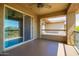 Open patio with sliding glass doors and balcony overlooking desert landscape and neighboring properties at 2425 W Bronco Butte Trl # 2028, Phoenix, AZ 85085