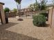 This spacious backyard includes gravel, a fire pit, and a fence around the yard at 2514 W Big Oak St, Phoenix, AZ 85085