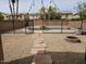 This fantastic backyard features stone pavers, gravel, a fence with a pool behind, and string lights at 2514 W Big Oak St, Phoenix, AZ 85085