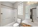 Bathroom features tile, tub with shower, single sink vanity and glass block window at 2610 W Sat Nam Way, Phoenix, AZ 85086