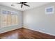 Bright bedroom with hardwood floors, ceiling fan, and plantation shutters at 2610 W Sat Nam Way, Phoenix, AZ 85086