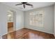 Bedroom showcasing wood floors, plantation shutters, arched doorway and ensuite bathroom at 2610 W Sat Nam Way, Phoenix, AZ 85086