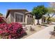 Charming home exterior with desert landscaping, including colorful bougainvillea and a view of the tile roof at 2610 W Sat Nam Way, Phoenix, AZ 85086