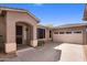 Attractive home exterior showing front door, tan stucco, tile roof, desert landscaping, and attached two car garage at 2610 W Sat Nam Way, Phoenix, AZ 85086