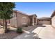 Tan home exterior with tile roof, desert landscaping, and a spacious driveway leading to the attached garage at 2610 W Sat Nam Way, Phoenix, AZ 85086