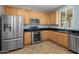 Kitchen featuring stainless steel appliances, wood cabinets, black countertops, and tile flooring at 2610 W Sat Nam Way, Phoenix, AZ 85086