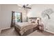 Comfortable bedroom with a ceiling fan, window and decorative tree art hanging on the wall at 269 W Seaside Dr, Casa Grande, AZ 85122