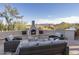Scenic outdoor patio with fireplace, cozy seating, and breathtaking desert landscape views at 28437 N 112Th Way, Scottsdale, AZ 85262
