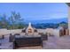 Outdoor patio featuring cozy seating, a fireplace, built-in grill and stunning mountain views at 28437 N 112Th Way, Scottsdale, AZ 85262