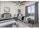 Comfortable bedroom featuring two twin beds, ceiling fan, artwork, and a window with desert views at 28437 N 112Th Way, Scottsdale, AZ 85262