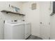 Clean laundry room showcasing modern washer and dryer, floating shelves and storage space for laundry essentials at 28437 N 112Th Way, Scottsdale, AZ 85262