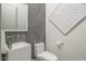Stylish powder room featuring modern sink, toilet, hardware, and a decorative accent wall and artwork at 28437 N 112Th Way, Scottsdale, AZ 85262