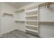 Bright walk-in closet featuring lots of shelf space and wood trim and luxury vinyl plank flooring at 28437 N 112Th Way, Scottsdale, AZ 85262