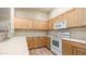 Bright kitchen with wooden cabinets, white appliances, and a modern sink at 3131 E Legacy Dr # 2055, Phoenix, AZ 85042