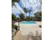 Community pool surrounded by lush landscaping and towering palm trees on a sunny day with fluffy clouds at 3131 E Legacy Dr # 2055, Phoenix, AZ 85042