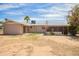 View of the backyard revealing a covered patio, desert landscaping, and access to the home at 3136 W Voltaire Ave, Phoenix, AZ 85029