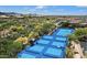 Aerial view of community tennis and pickleball courts surrounded by desert landscape and mountain views at 34457 N Legend Trail Pkwy # 1013, Scottsdale, AZ 85262