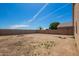Expansive dirt backyard with block wall providing privacy, perfect for customizing and creating your dream outdoor space at 34463 N Karan Swiss Cir, San Tan Valley, AZ 85143