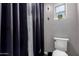 Bright bathroom features a shower with black curtain, and a toilet with window at 34463 N Karan Swiss Cir, San Tan Valley, AZ 85143