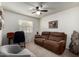 Comfortable living room with a plush brown sofa, ceiling fan, and a bright window for natural light at 3730 W Michigan Ave, Glendale, AZ 85308