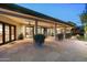 Large covered back patio featuring stone flooring, potted plants, and views of the landscaped backyard at 3901 E San Miguel Ave, Paradise Valley, AZ 85253