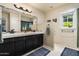 Elegant bathroom featuring a window view, dual sinks, dark cabinets, and a large mirror at 3901 E San Miguel Ave, Paradise Valley, AZ 85253