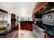 Gourmet kitchen with premium stainless appliances, dark countertops, and breakfast bar seating at 3901 E San Miguel Ave, Paradise Valley, AZ 85253