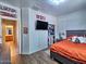 Bright bedroom with wood floors, view to bathroom, closet, and mounted flat screen television at 44182 W Juniper Ave, Maricopa, AZ 85138