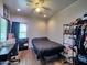 Modern bedroom features desk, ceiling fan, and closet with hanging clothes at 44182 W Juniper Ave, Maricopa, AZ 85138