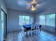 Inviting dining room with a ceiling fan, tile flooring, and large windows at 44182 W Juniper Ave, Maricopa, AZ 85138