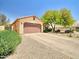 Charming single-story home showcasing a well-maintained front yard and a two-car garage at 44182 W Juniper Ave, Maricopa, AZ 85138