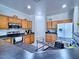 Well-equipped kitchen features oak cabinets, black countertops, and stainless steel appliances at 44182 W Juniper Ave, Maricopa, AZ 85138