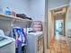 This laundry room has a washer, dryer, and storage shelf at 44182 W Juniper Ave, Maricopa, AZ 85138