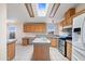 Bright kitchen with wood cabinets, island, skylight and stainless steel appliances at 49039 N 24Th Ave, New River, AZ 85087