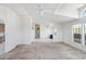 Spacious living room boasts multiple windows, a ceiling fan, skylights, and neutral-colored carpeting at 49039 N 24Th Ave, New River, AZ 85087